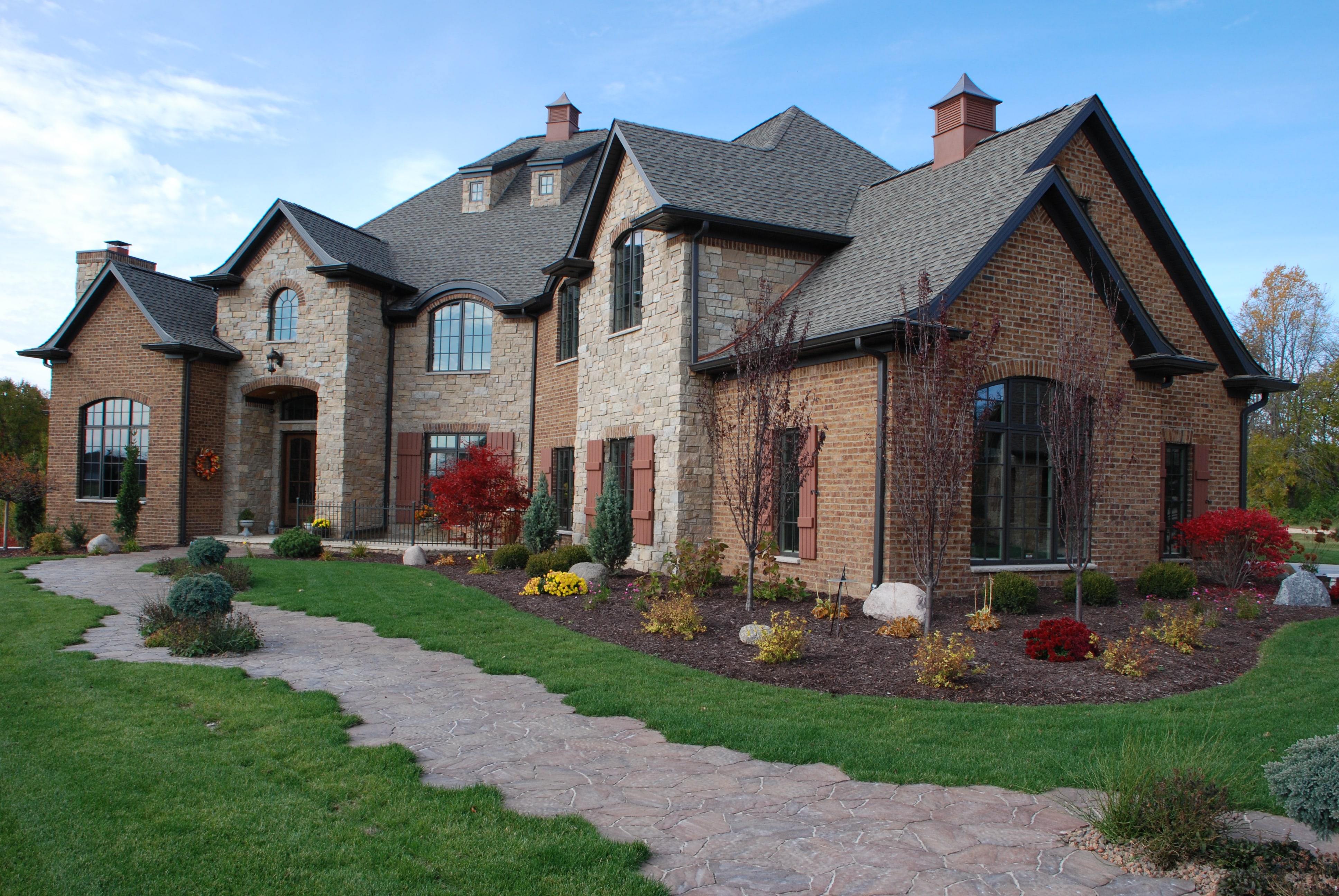 image of a house with a stone path and landscaping around the edges.