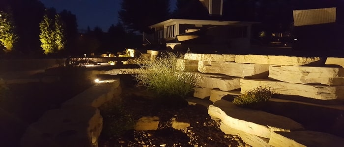 outdoor lighting with large stone walls and grasses