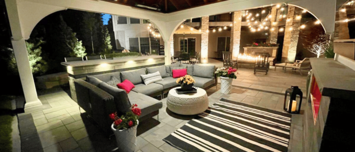 Outdoor entertaining area lit up with outdoor LED lighting and a fire feature by Outdoor Innovations.