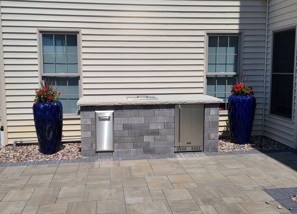 Patio with serving counter that includes refrigerator, and trash receptacles.