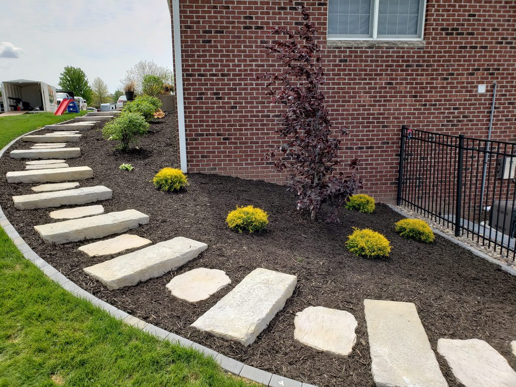 Custom Pavers that create a set of stairs that wrap around the side of a house. 